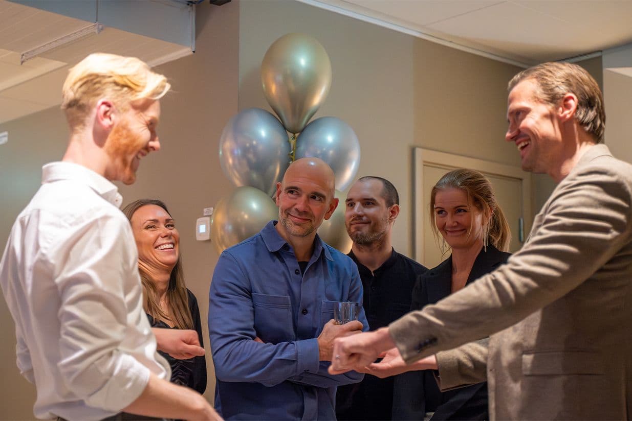 Gäster reagerar på trollkarl under mingel på företagsevent